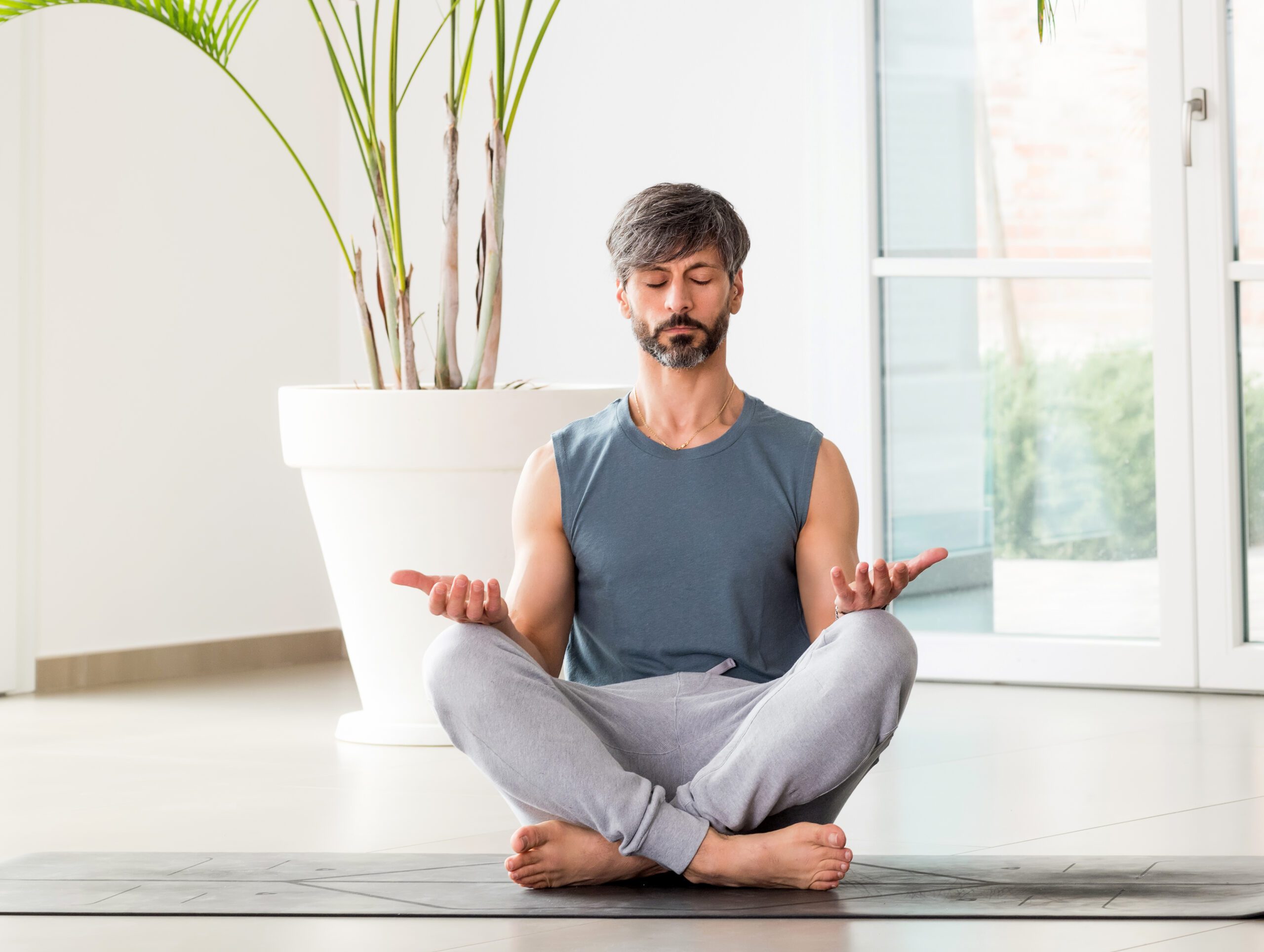 A barefoot man sitting in a lotus pose.